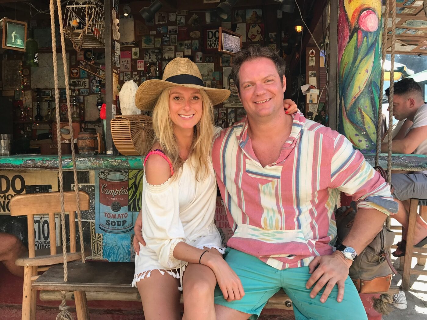 Phoebe and Chris on a swing at a beach bar